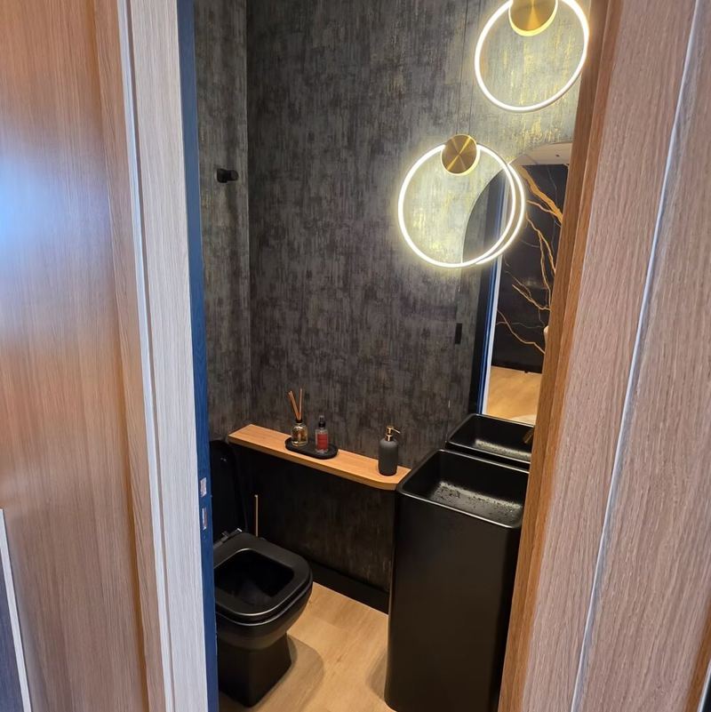 Sales Gold: lavabo com louças pretas e papel de parede texturizado