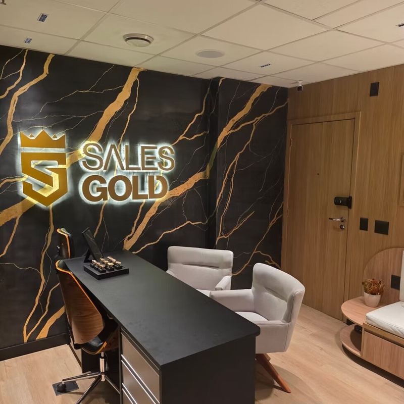 Sales Gold: recepção com logo iluminado sobre mármore preto e dourado