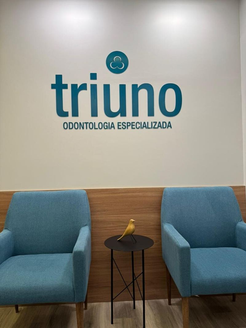 Triuno: painel da marca com poltronas de espera